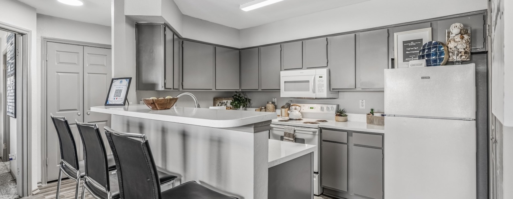 Kitchen with serving counter and chairs at Fifteen12 apartments for rent in Bryan, TX.