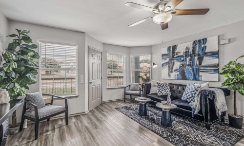 Living room with a couch, chair, and TV at Fifteen12 in Bryan, Texas.